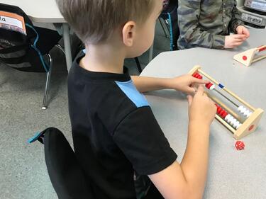 Young student sitting at a table, learning math