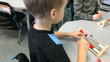 Young student sitting at a table, learning math