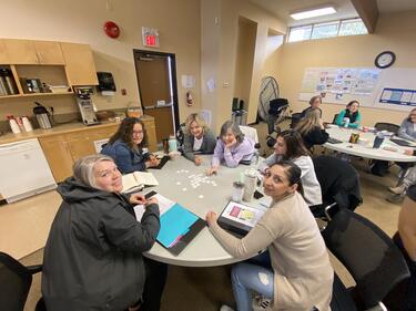 Group of staff sitting around a table, collaborating