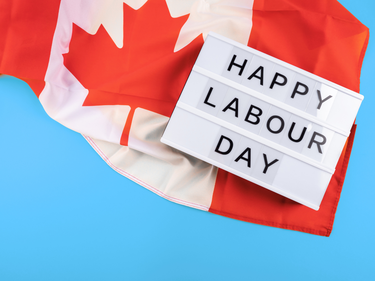 Canadian flag with a sign displaying "Happy Labour Day."