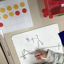 Learning Math, paper and student hand.